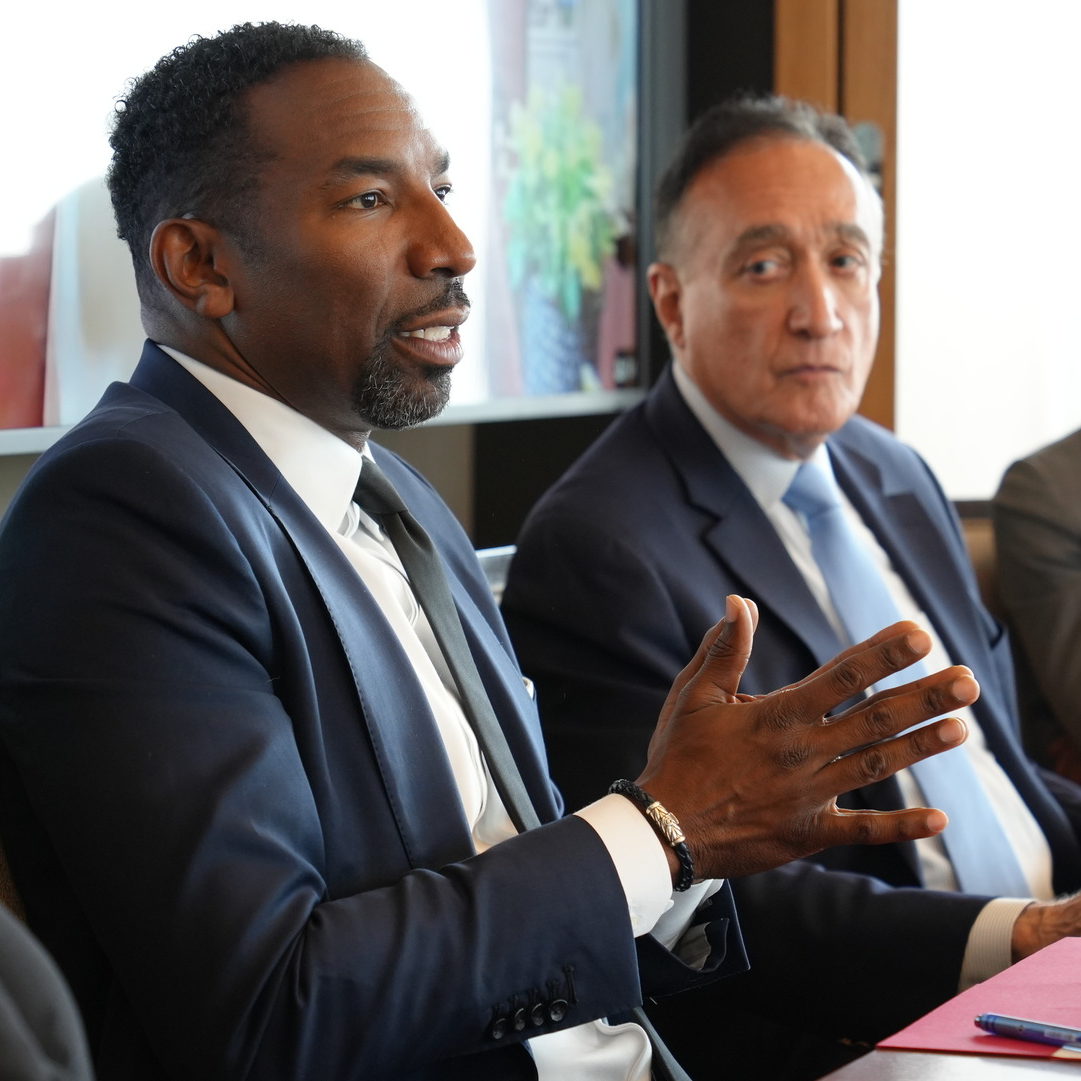 A man in business attire talking at a conference table