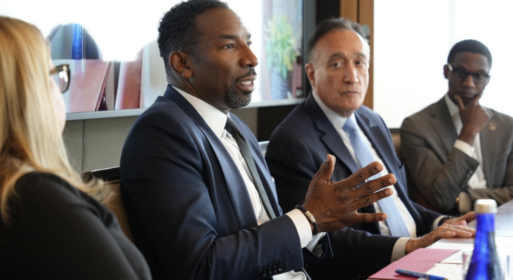 A man in business attire talking at a conference table