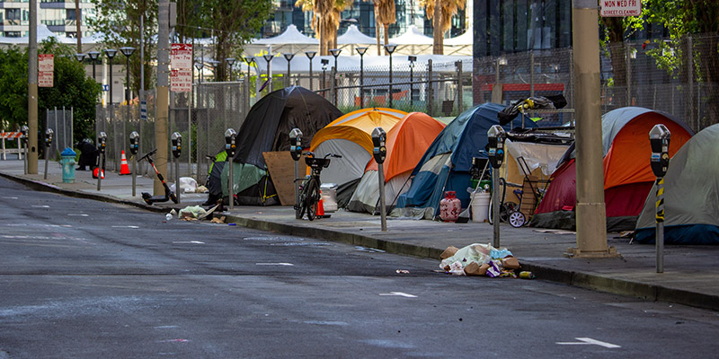 Group of tents on the sidewalk in an urban environment