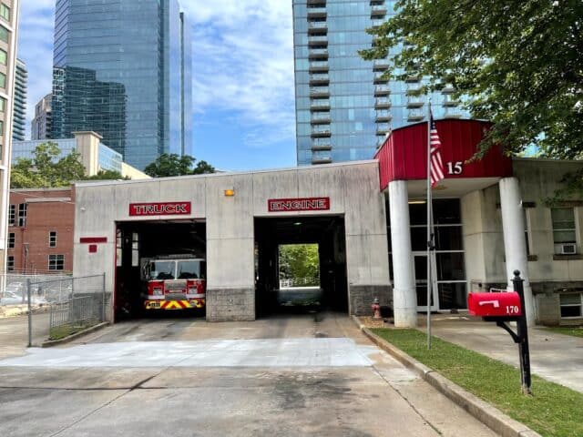 A photo of Fire Station 15 with two fire truck bays; one is empty.