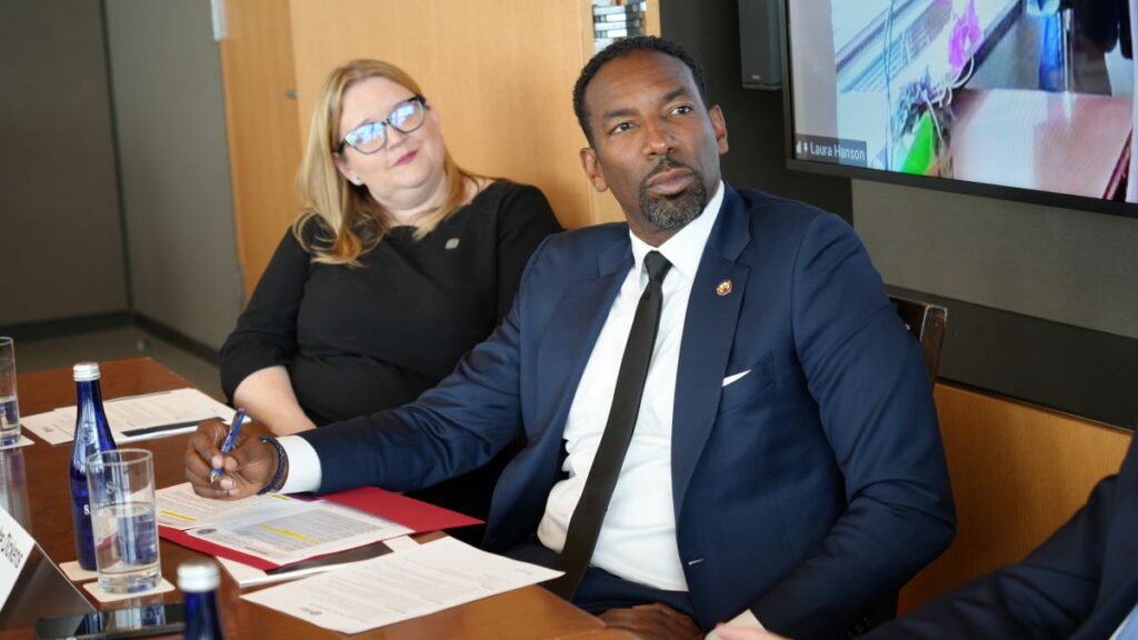 Mayor Andre Dickens and Susan Thomas, President of Fifth Third CDC, seated looking at a speaker who cannot be seen in the photo.