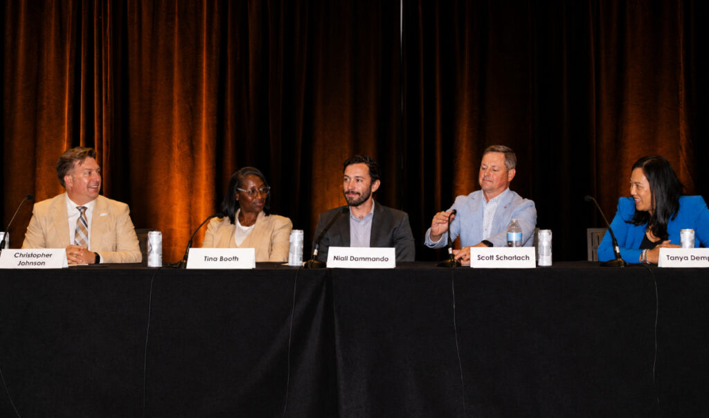 A group of five people speaking at a panel
